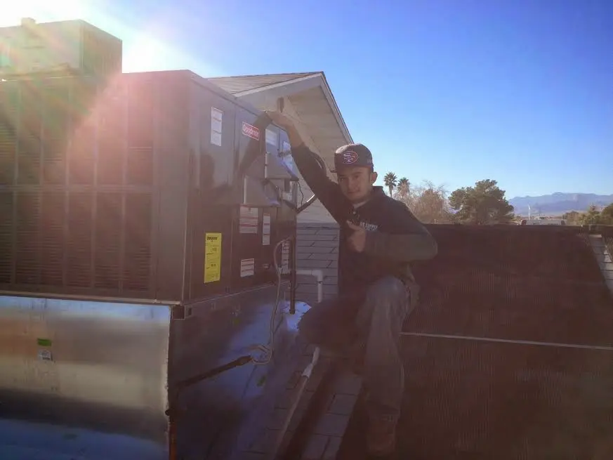 HVAC technician performing Air Duct Cleaning on a rooftop unit in Gateway